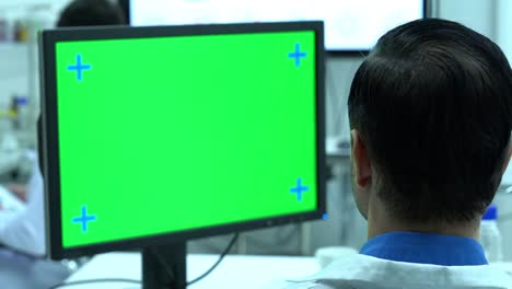 Scientist-male-talking-about-working-in-modern-laboratory-or-medical-center.-Background-monitor-green-screen.-Concept-of-science,-testing-development-and-lab-industry.