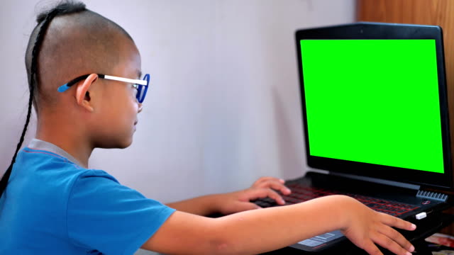 Asiaten-Knabe-Laptop-Computer-und-green-Screen-spielen.-Glückliche-Kinder-spielen-Computer-zu-Hause-genießen.