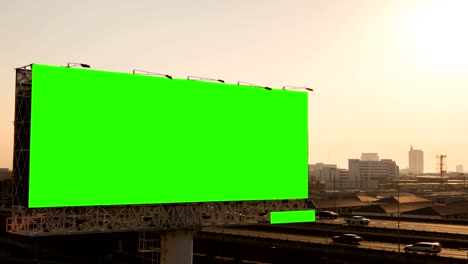 Green-screen-of-advertising-billboard-on-expressway-during-the-sunset-with-city-background-in-Bangkok,-Thailand.-Time-lapse.
