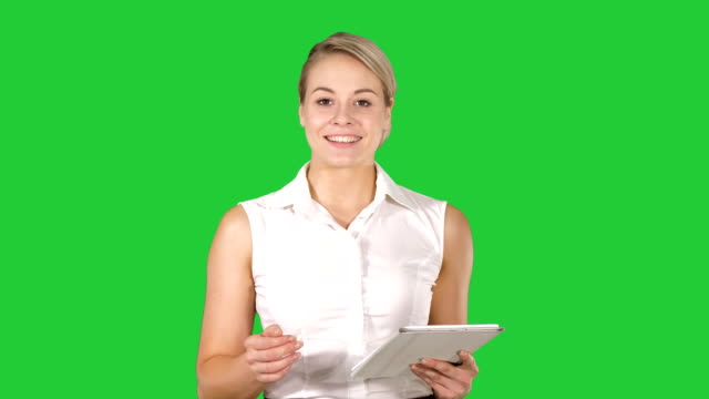 Junge-lächelnde-Geschäftsfrau-mit-Tablet-PC-umblättern-und-suchen-der-Kamera-auf-einem-Green-Screen,-Chroma-Key