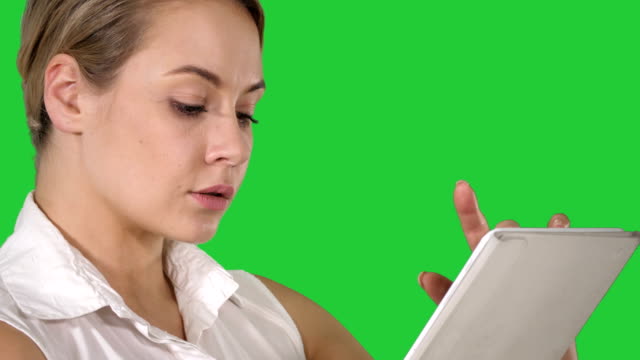 Junge-attraktive-Geschäftsfrau-hält-einen-Tabletcomputer-auf-einem-Green-Screen,-Chroma-Key