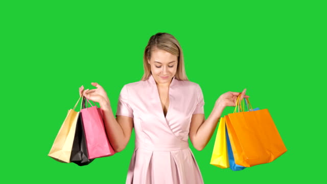 Einkaufen-Frau-glücklich-lächelnd-Holding-shopping-Bags-Iwhile-zu-Fuß-auf-einem-Green-Screen,-Chroma-Key