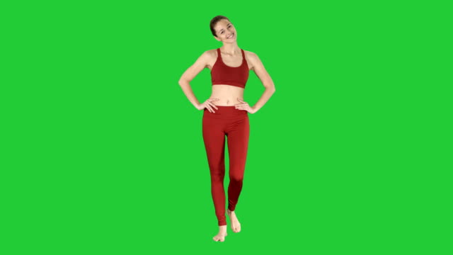 Mature-woman-stretching-her-neck-and-walking-on-a-Green-Screen,-Chroma-Key