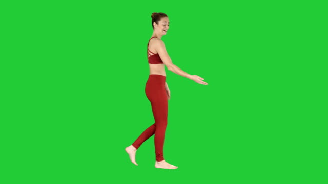 Weibliche-Sportlerin,-die-Streckung-der-Arme-während-Spaziergang-auf-einem-Green-Screen,-Chroma-Key
