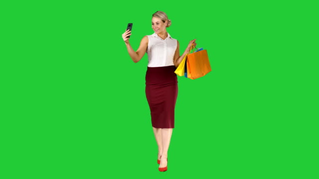 Сheerful-Frau-mit-Einkaufstüten-unter-Selfie-auf-einem-Green-Screen,-Chroma-Key
