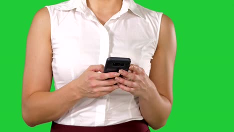 Women's-hands-holding-cell-telephone-on-a-Green-Screen,-Chroma-Key