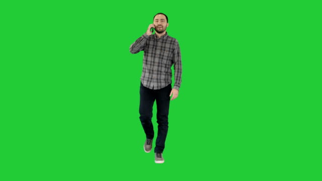 Young-man-talking-on-mobilephone-on-a-Green-Screen,-Chroma-Key