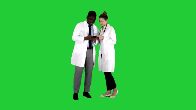 Medical-team-looking-at-phone-together-on-a-Green-Screen,-Chroma-Key