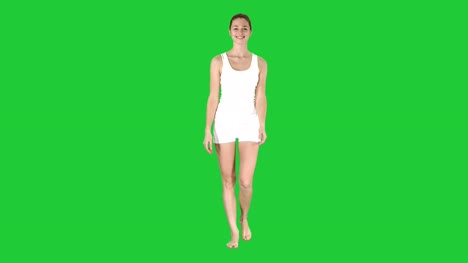 Joven-sexy-caminando-y-sonriendo-vestida-en-shorts-blancos-y-camiseta-en-una-pantalla-verde-Chroma-Key
