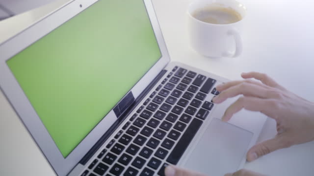 Joven-mujer-caucásica-en-sus-30s-usando-su-computadora-portátil,-con-una-pantalla-verde-para-indicar-el-nuevo-contenido