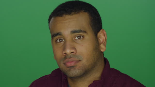 Young-African-American-man-looking-intimidating,-on-a-green-screen-studio-background