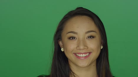 Schöne-junge-Frau,-die-lächelnd-auf-einem-green-Screen-Studio-Hintergrund