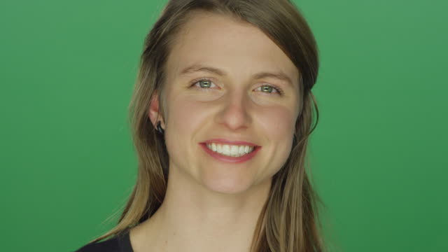 Junge-Frau-lächelt-nach-weinend-auf-einem-green-Screen-Studio-Hintergrund