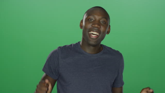 Young-African-American-Mann-tanzen-und-lustige-Grimassen,-auf-einem-green-Screen-Studio-Hintergrund