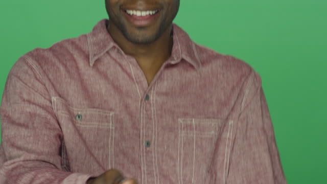 Young-African-American-man-dancing-and-being-silly,-on-a-green-screen-studio-background