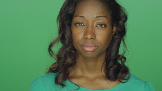 Beautiful-African-American-woman-looking-sad,-on-a-green-screen-studio-background