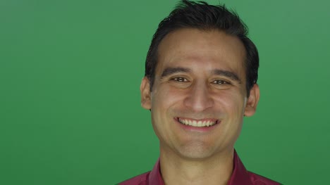 Ethnic-man-nodding-and-smiling,-on-a-green-screen-studio-background