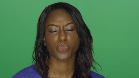 Beautiful-African-American-woman-smiling-and-making-silly-faces,-on-a-green-screen-studio-background