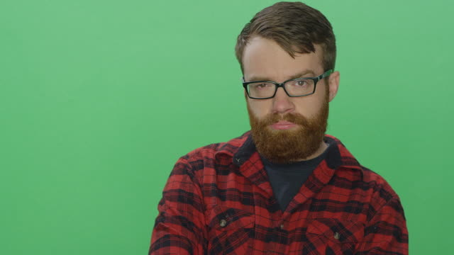 Young-bearded-man-poses-with-attitude,-on-a-green-screen-studio-background
