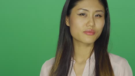 Hermosa-mujer-asiática-sonriendo-y-siendo-seductora,-sobre-un-fondo-de-estudio-de-pantalla-verde