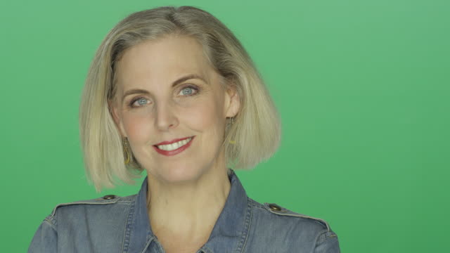 Schöne-ältere-Frau-lächelnd-und-verspielt,-auf-einem-green-Screen-Studio-Hintergrund