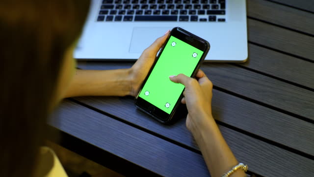 Chica-joven-es-celebración-de-Smartphone-con-pantalla-verde