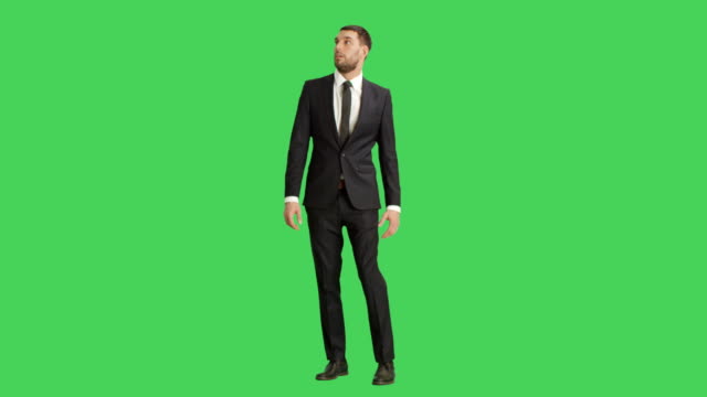 Long-Shot-of-a-Handsome-Businessman-Looking-Around-Frightened.-Shot-on-a-Green-Screen-Background.