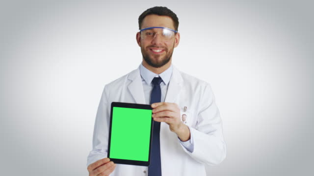 Tiro-medio-de-un-científico-sonriente-presentando-a-nosotros-Tablet-PC-con-pantalla-verde-de-Mock-up-aislada.-Disparo-con-fondo-blanco.