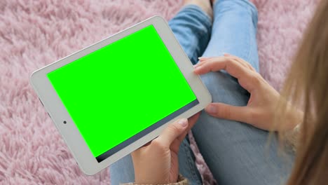 Mujer-mirando-a-la-computadora-de-tableta-con-pantalla-verde