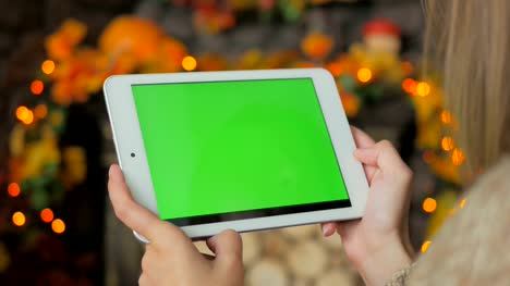 Frau-schaut-in-Tabletcomputer-mit-grünen-Bildschirm