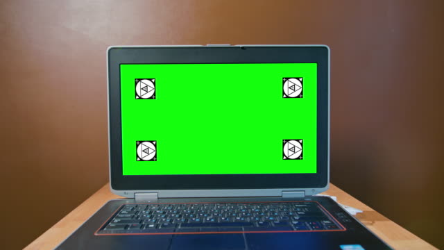 Pan-de-la-cámara-con-el-ordenador-portátil-con-pantalla-verde