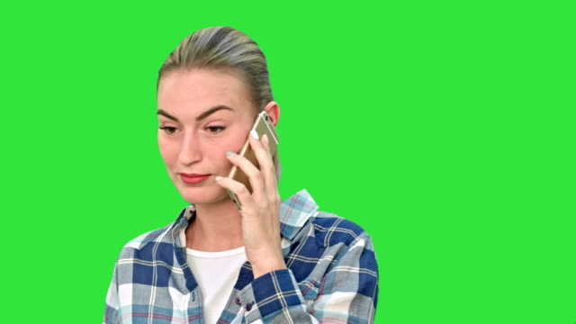 Beautiful-young-woman-talking-on-mobile-phone-seriously-on-a-Green-Screen,-Chroma-Key