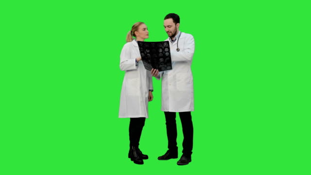 Doctors-examine-xray-and-discuss-successful-result-of-operation-on-a-Green-Screen,-Chroma-Key