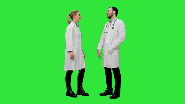 Young-medical-students-give-each-other-five-after-exam-on-a-Green-Screen,-Chroma-Key