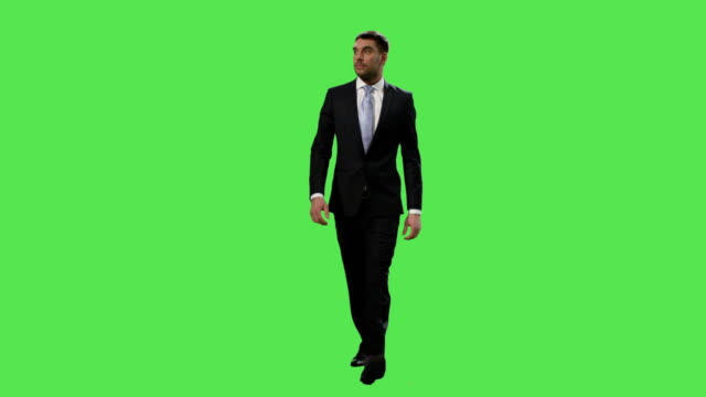 Empresario-en-un-traje-está-caminando-sobre-una-maqueta-pantalla-verde-de-fondo.
