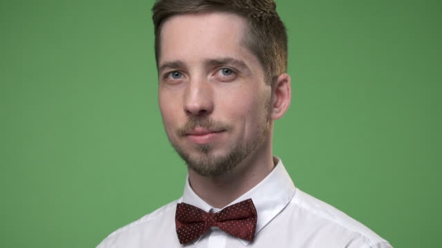 Close-up-of-a-young-student-in-white-shirt-with-a-bow-tie,-chroma-key-green-screen-background