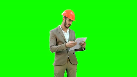 Architect-in-helmet-checking-construction-plan-on-a-Green-Screen,-Chroma-Key