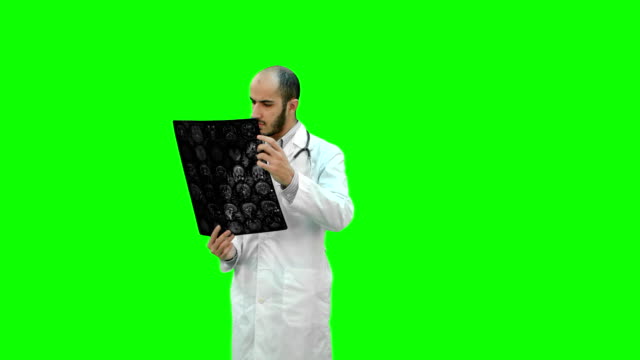 Doctor-examinar-resultados-de-rayos-sobre-una-pantalla-verde-Chroma-Key