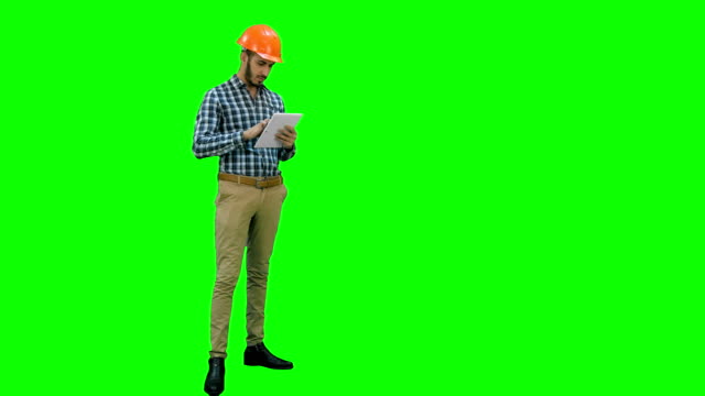 Engineer-using-a-wireless-tablet-to-check-construction-project-on-a-Green-Screen,-Chroma-Key