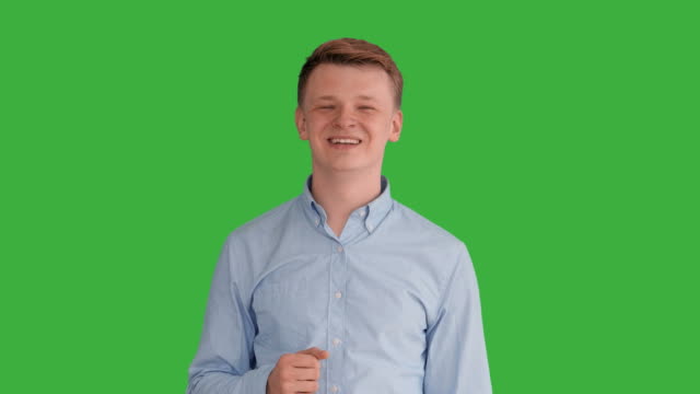 Young-Handsome-Men-Acting-in-Front-of-a-Green-Screen.-Blond-Hair,-Blue-Shirt-and-Blue-Trousers.-Dancing,-Thinking,-Turning-Around-and-Talking-to-the-Camera.