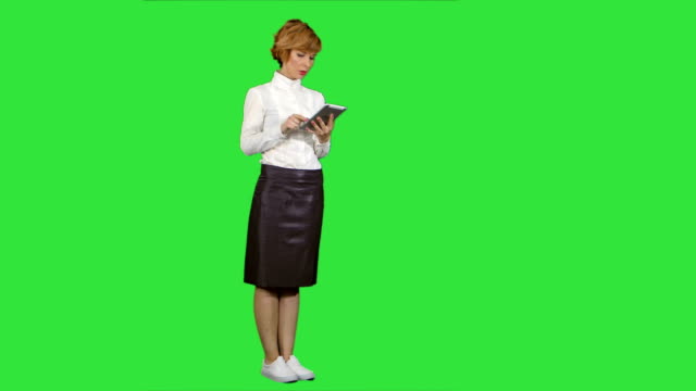 Hübsche-junge-Frau-mit-Tablet-auf-einem-Green-Screen,-Chroma-Key