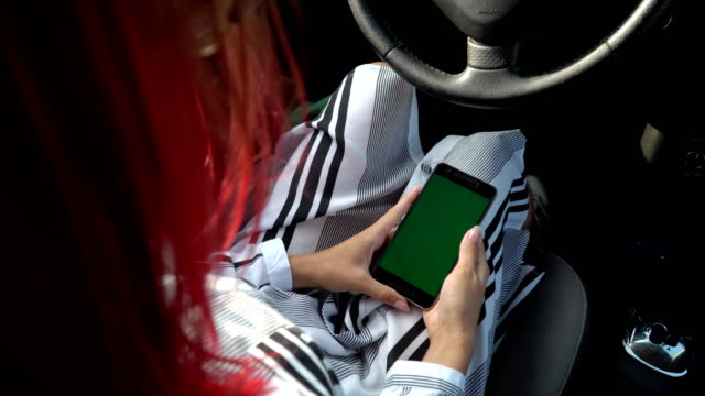 Business-Mädchen-in-intelligente-Kleidung-mit-ihrem-Smartphone-in-ihrem-Auto,-Richtung-green-Screen-Chroma-Key-4k