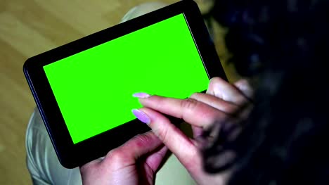 Back-view-of-woman-at-home-using-electronic-tablet.-UHD-stock-video,-alpha-matte-included