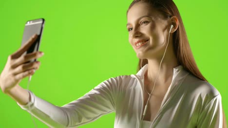 Attractive-girl-young-fashion-model-interract-with-her-smartphone-and-take-selfie-greenscreen-prores-shoot-on-ursa-mini-pro