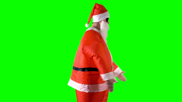 Santa-Claus-macht-tanzende-Bewegungen-mit-Armen-und-Beinen-auf-einem-grünen-Hintergrund.