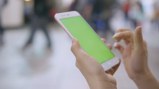 Frau-mit-Smartphone-mit-green-Screen-auf-der-Straße.