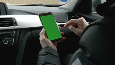 GREEN-SCREEN-Mann,-hält-sein-Smartphone-im-Auto