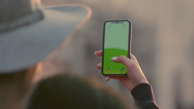 Woman-holding-green-screen-smartphone
