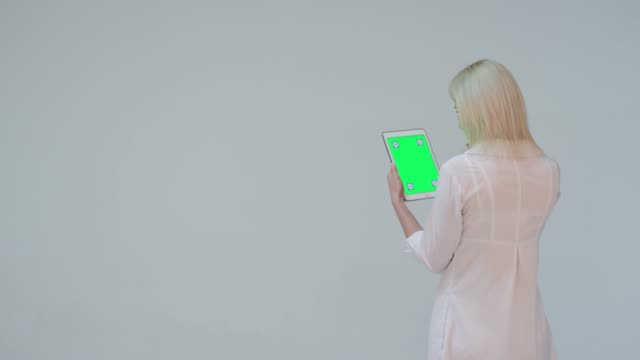 Médico-presionando-la-pantalla-verde-de-un-tablet-PC