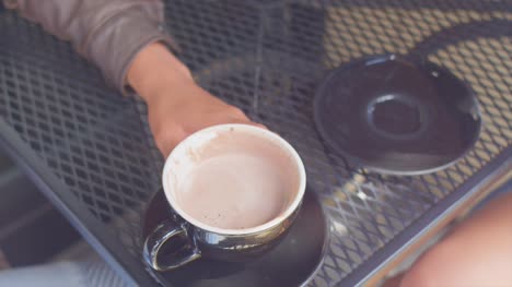 Nahaufnahme-von-zwei-Kaffeetassen-auf-dem-Tisch,-jemand-nimmt-einen-Drink